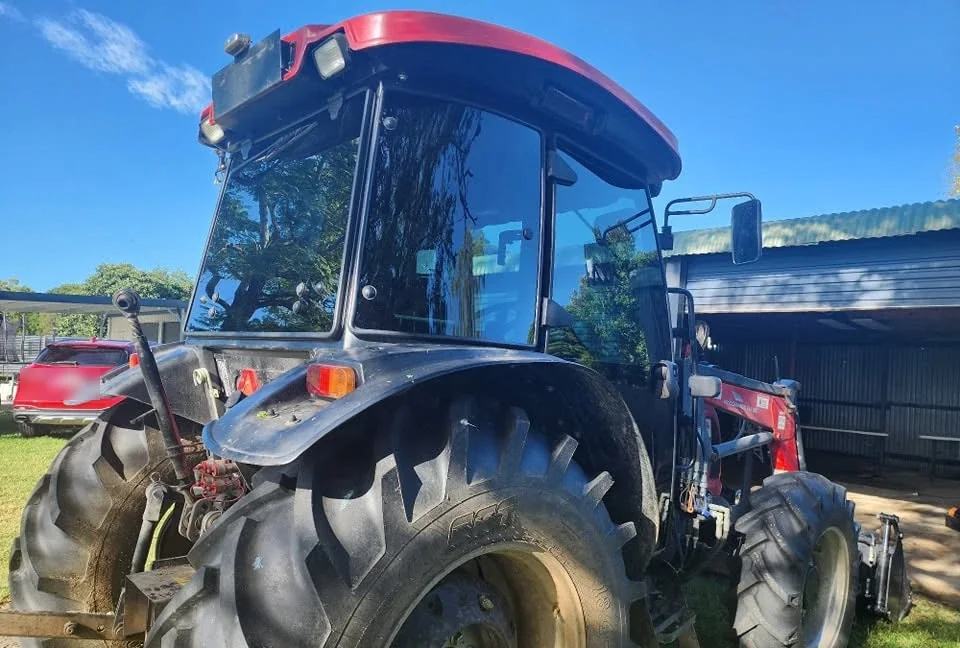 Red Massey Ferguson tractor with a tinted glass cab