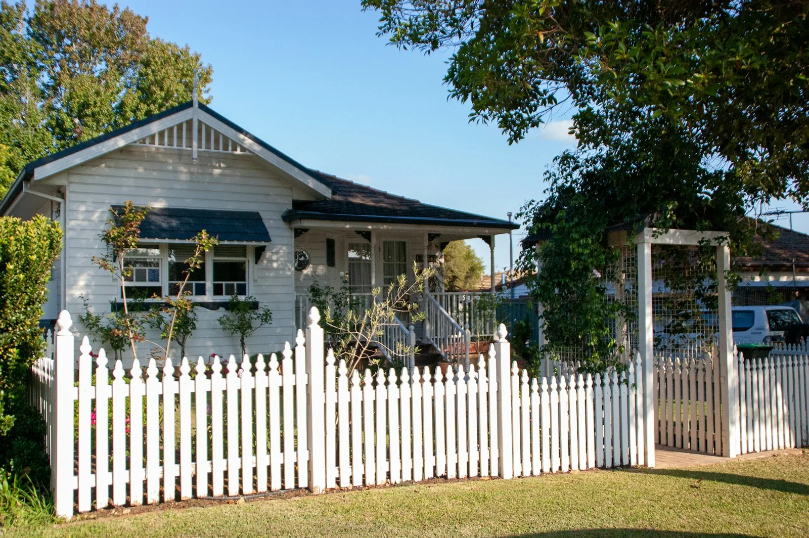 White weatherboard Australian home with a picket fence, the kind of house that benefits from window tint